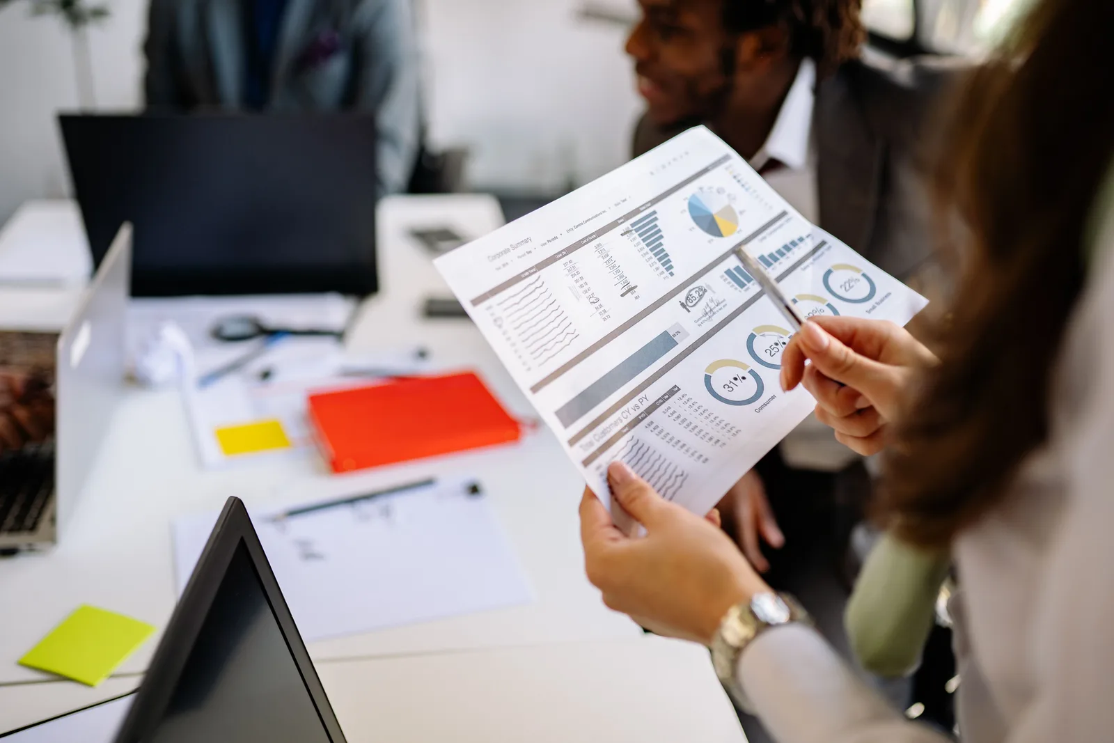 Professionals reviewing business charts and documents in a team meeting. Campaign measurement checklist: claim and chart gates before release