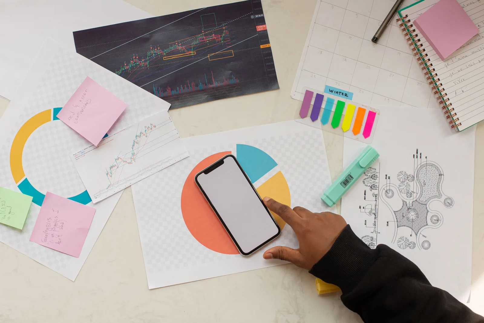 Creative workspace with charts, phone, and stationery, ideal for business planning. Common marketing attribution questions, answered