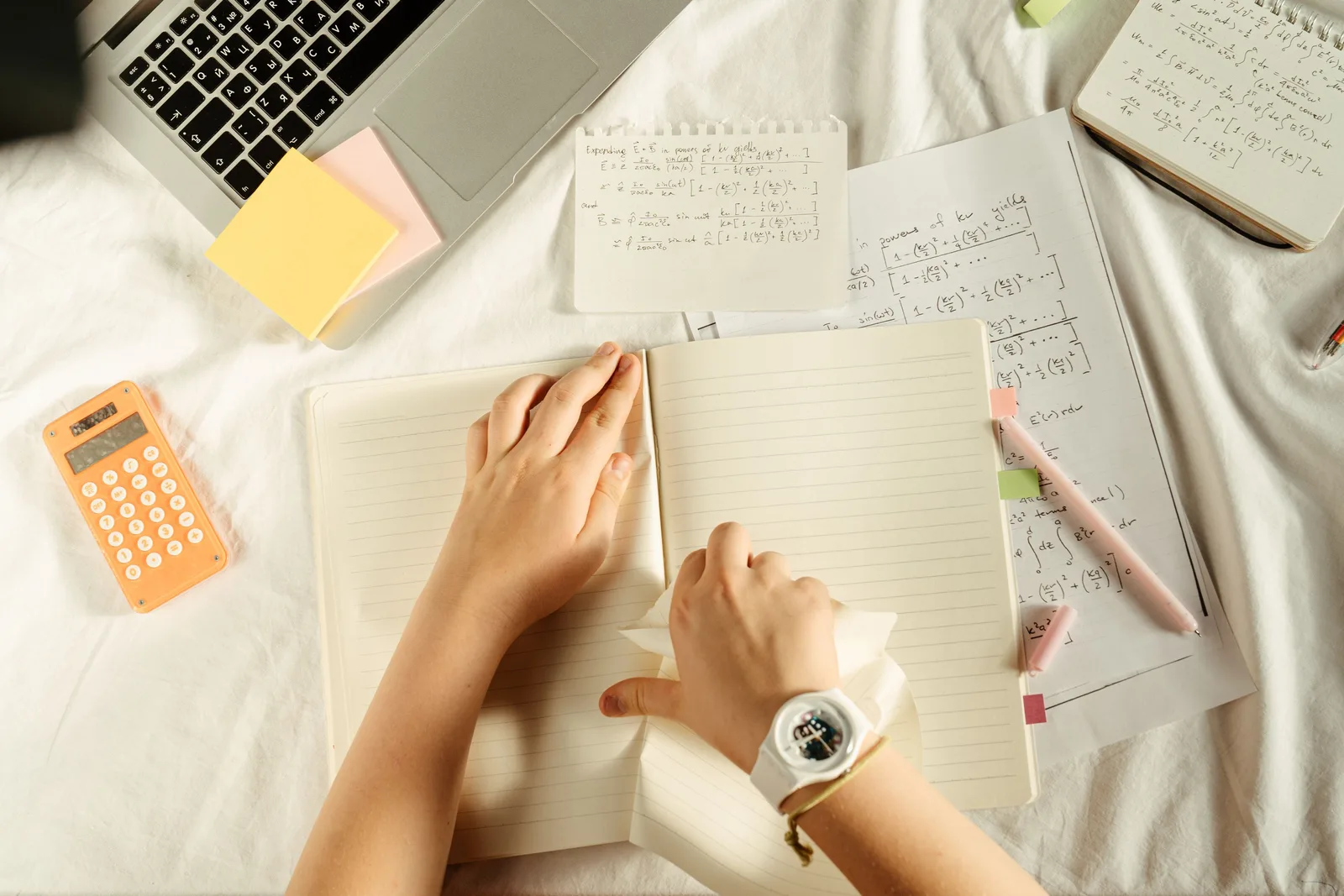 Overhead view of study materials with a laptop, calculator, and notebook on a desk. The honest guide to marketing attribution