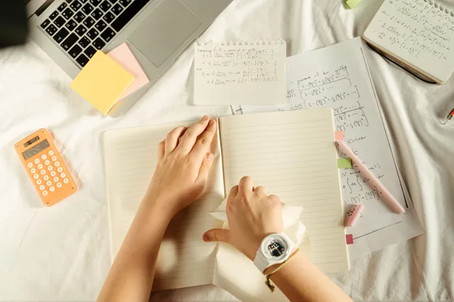 Overhead view of study materials with a laptop, calculator, and notebook on a desk. The honest guide to marketing attribution