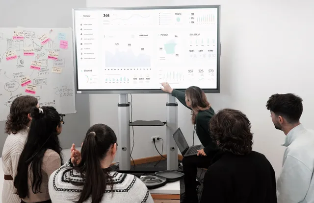 Group of professionals engaged in a business presentation examining charts on a large screen. Where marketing mix models go wrong: patterns worth catching early