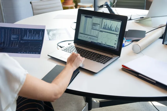 Business person evaluating financial charts on a laptop in a modern office setting. How to think about marketing mix modeling trends, updated for 2027